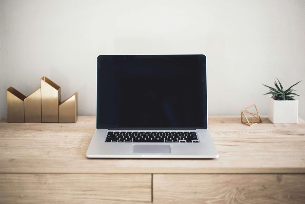 Image of a laptop sitting on a desk with decorative pieces. If you struggle with depression, learn how online therapy in Parkland, FL can help!