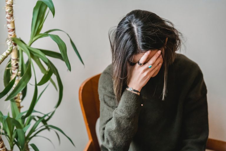 Photo of a woman with her face in hand. Learn what anxiety is, how it can affect you, and how anxiety therapy in Coconut Creek, Fl can help support you.
