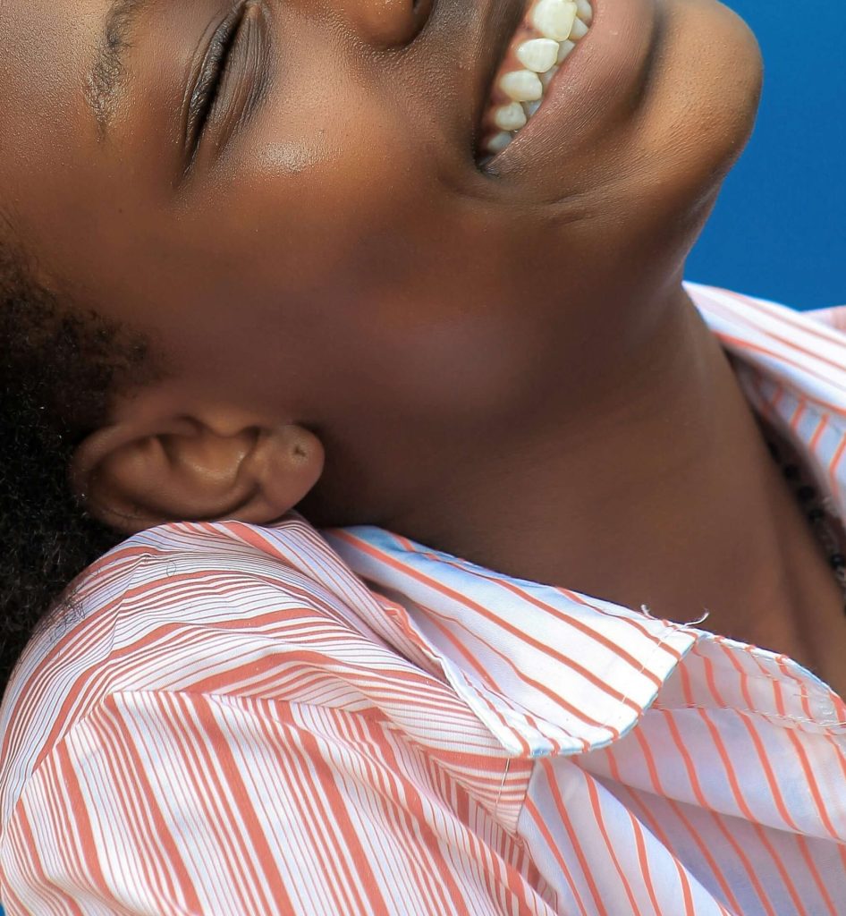 Image of a smiling young African American woman with her eyes closed. Discover how depression counseling in Parkland, FL can help you when it comes to coping with your self-esteem.