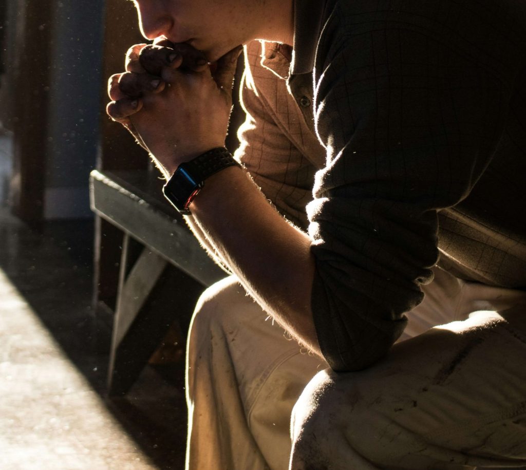 Image of a man sitting on a bench resting his chin on his hands while the sun shines on him. With the help of depression counseling in Parkland, FL you can manage your depression symptoms in healthy ways.