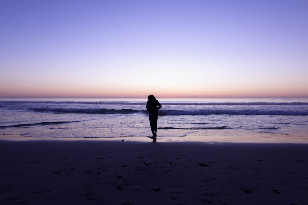 woman on beach | depression counseling in parkland, fl | depression therapist in parkland, fl | major life changes | major life changes and depression | signs of depression | 33073 | 33067 | 33076 Image of a woman wearing a jacket and walking on the beach near the water during sunset. Cope with your major life changes in healthy ways with the help of depression counseling in Parkland, FL.