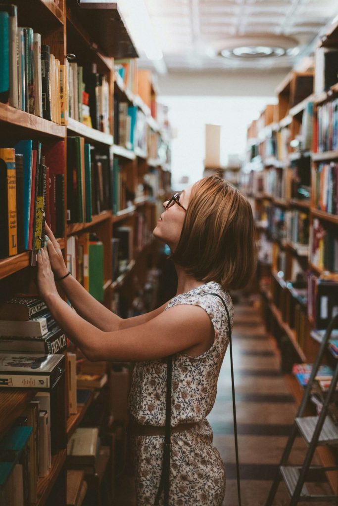 woman in library | anxiety therapy in coconut creek, fl | cbt for anxiety in coconut creek, fl | anxiety therapist | cbt therapist | cbt therapy | 33063 | 33066 | 33073 Image of a woman standing in a library searching for a book. Anxiety can be overwhelming during a life transition. Learn how CBT for anxiety in Coconut Creek, FL can help you cope with your symtpoms.
