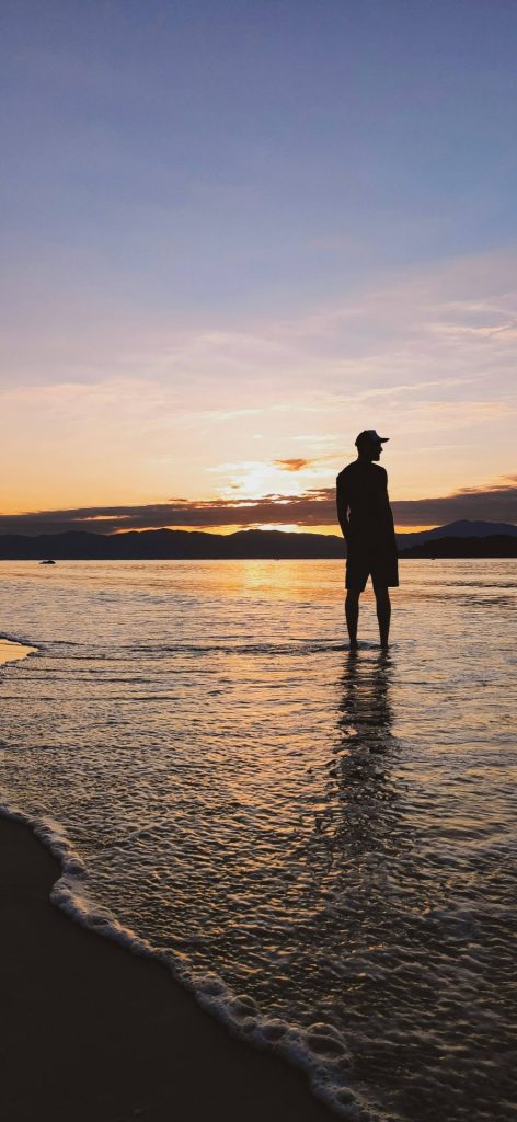 man on beach | anxiety therapy in coconut creek, fl | cbt for anxiety in coconut creek, fl | anxiety therapist | cbt therapist | cbt therapy | 33063 | 33066 | 33073 Image of a thoughtful man standing on the beach in the water during sunset. With CBT for anxiety in Coconut Creek, FL you can begin working to overcome your anxiety due to life transitions.