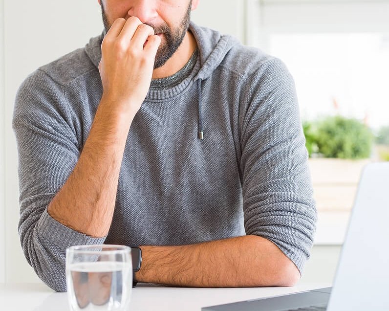 man chewing nails | anxiety therapy in coconut creek, fl | anxiety therapist in coconut creek, fl | cognitive behavioral therapy | cbt therapist | 33063 | 33066 | 33073 Image of an anxious man looking at a laptop as he chews his nails. Overcome your Sunday scaries and begin coping in healthy ways with the support of an anxiety therapist in Coconut Creek, FL.
