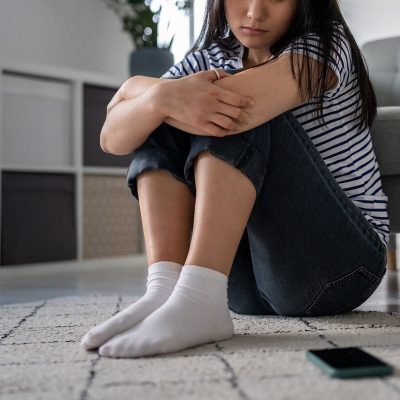 Shows a woman looking at her phone. Represents how an anxiety therapist in boca raton, fl can support you with cognitive behavioral therapy florida.
